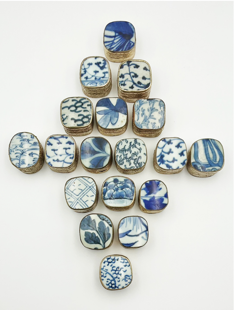 A collection of small shard boxes with blue and white porcelain lids. A collection of small shard boxes with blue and white porcelain lids.